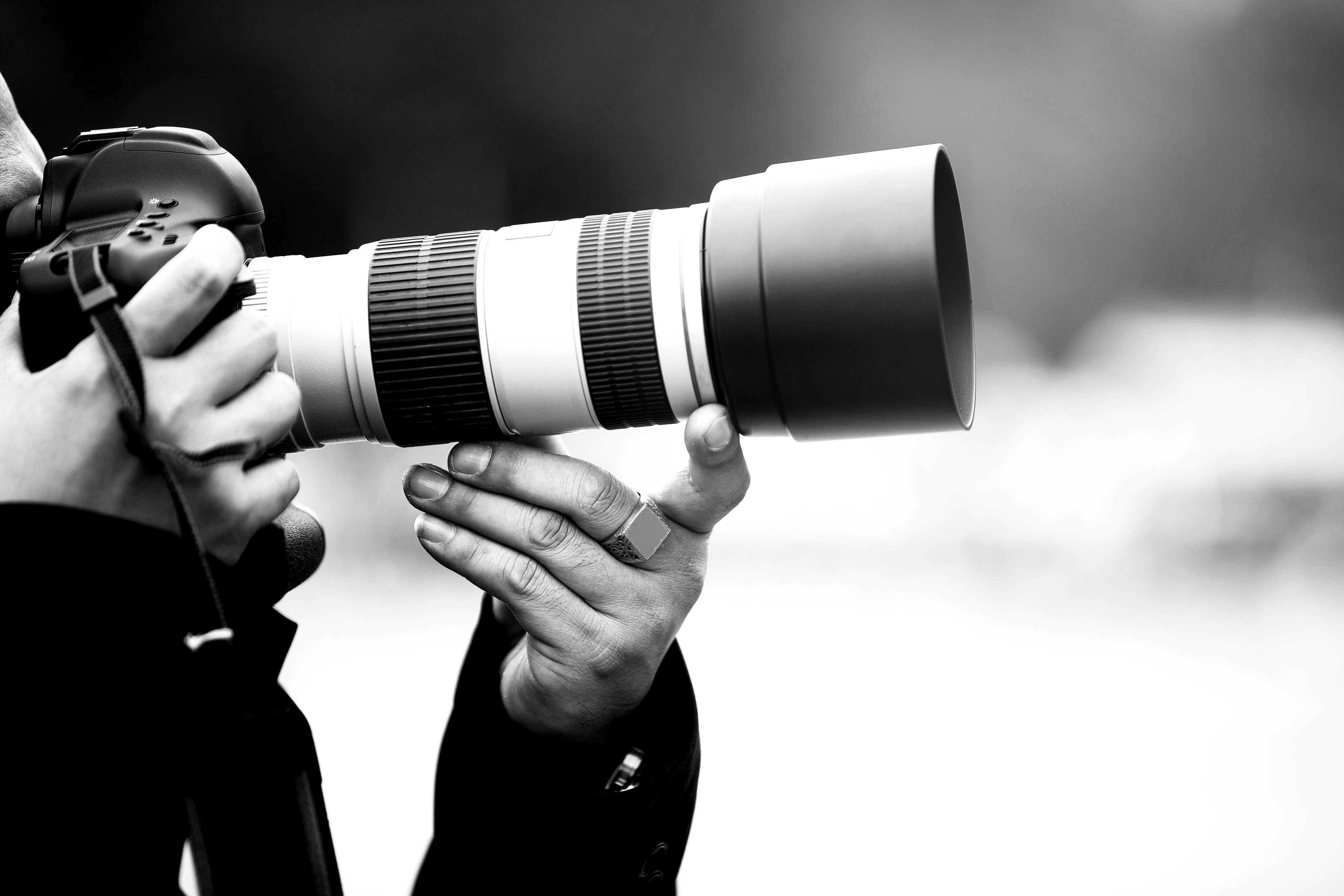 hands holding long lens camera